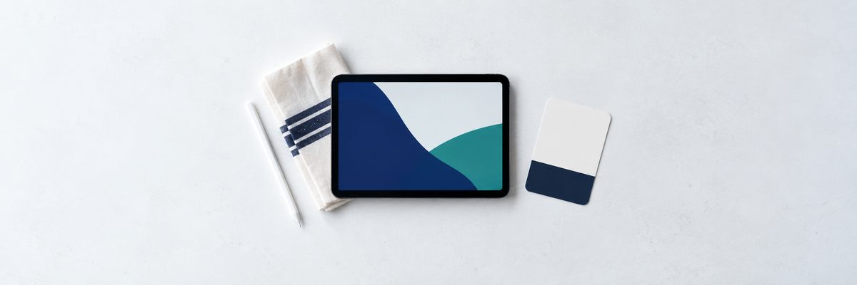 A tablet and stylus on a counter beside a single card