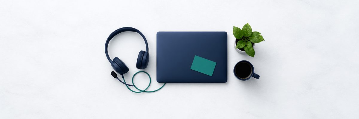 A compact remote workspace, headset coiled beside a laptop
